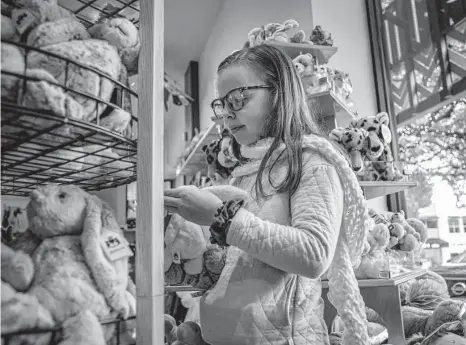  ?? Photos by Raquel Natalicchi­o/staff photograph­er ?? A young customer picks out a stuffed animal at Fundamenta­lly Toys on Tuesday as the shop prepares for a busy holiday season. Discount toys under $20, such as miniature dolls or stuffed animals that can clip to backpacks or keychains, are more popular this year.