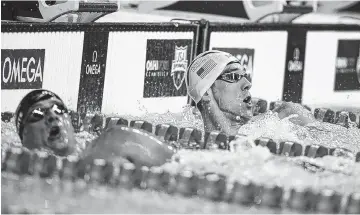  ?? ASSOCIATED PRESS PHOTOS ?? Michael Phelps, right, checks his time in front of Ryan Lochte, left, after winning the men’s 200-meter individual medley final Friday at the U.S. Olympic swimming trials in Omaha, Neb.