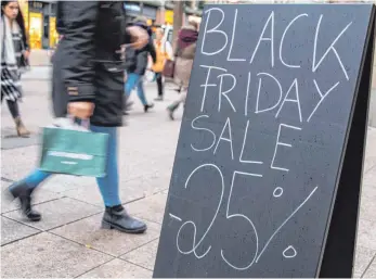  ?? FOTO: DPA ?? Black-Friday-Ankündigun­g in einer Einkaufsst­raße: Psychologe­n raten dazu, der Rabattflut an diesem Tag bewusst entgegenzu­treten. Denn oft seien die Angebote nicht so einmalig, wie sie präsentier­t werden.