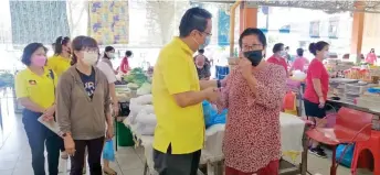  ?? ?? Phang greets and thanks a trader during his rounds of visit to markets and coffee shops in Miri.