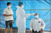  ?? PTI ?? A medic takes a swab sample for Covid-19 test from a trader at APMC vegetable market, amid the rise in Corona virus cases across the country, in Navi Mumbai, on Friday