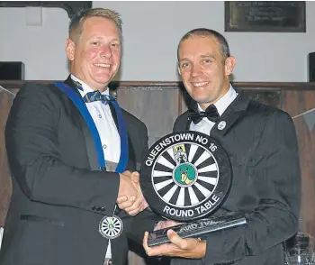  ??  ?? ROUND OF APPLAUSE: Outgoing chairman of Queenstown Round Table Dean Goldschmid­t, left, hands over the Tabler of the Year award to Darryl Aspey at the club’s recent induction dinner
