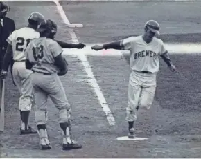  ?? MILWAUKEE JOURNAL ?? Brewers pitcher Skip Lockwood, a converted infielder, hits a home home run in the first game he pitched with the Brewers against the Washington Senators at County Stadium on May 19, 1970. Tommy Harper awaited Lockwood at the plate with Senators catcher...