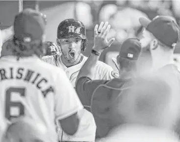  ?? Michael Ciaglo / Houston Chronicle ?? Astros shortstop Carlos Correa, center, works the dugout’s reception line after hitting a solo homer in the fifth of the 7-2 win over the Angels on Saturday at Minute Maid Park. Correa went 2-for-3 with that RBI.