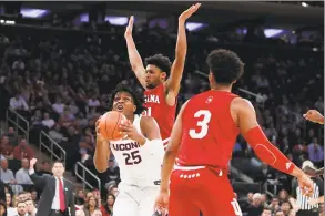  ?? Kathy Willens / Associated Press ?? UConn’s Josh Carlton (25) looks for a shot while defended by Indiana’s Jerome Hunter (21) and Justin Smith (3) on Tuesday night.