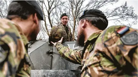  ?? Laetitia Vancon / New York Times ?? Soldiers from the Netherland­s prepare for an exercise on a German tank at Tank Battalion 414's base in Lohheide, Germany. The German-led tank battalion with Dutch soldiers gives a glimpse of what a “real European army” may look like one day.