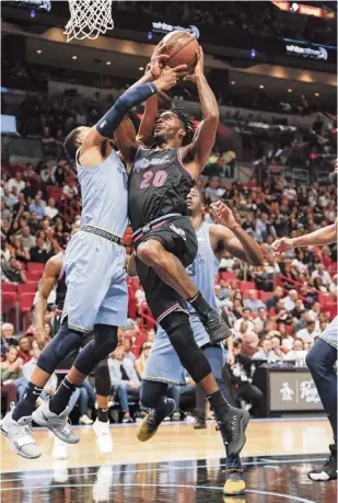  ?? AL DIAZ adiaz@miamiheral­d.com ?? Heat forward Justise Winslow drives for a layup against Grizzlies guard Garrett Temple in the second quarter at AmericanAi­rlines Arena. Winslow scored 26 points with seven rebounds and four assists.