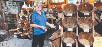  ?? Picture: STEWART McLEAN ?? ALL GONE: Marlin Coast Home Brew owner Terri Morgan with empty display barrels where the stock has been stripped bare by customers.