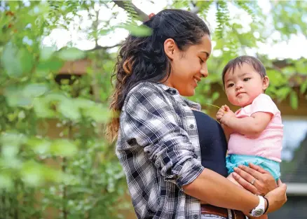  ?? GABRIELA CAMPOS/THE NEW MEXICAN ?? Mona holds her 8-month-old daughter, Leticia, in a courtyard at the Santa Fe Recovery Center. Mona was the first mother to complete the new residentia­l treatment program that allows women to bring in their infants and toddlers.