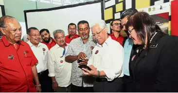  ??  ?? Smart technology: Idris (holding smartphone) trying out the Smart Mamak app after launching it at Restoran Ali Maju in Putrajaya. Looking on are UKM University Board Of Directors chairman Tan Sri Dr Ibrahim Saad (left), Presma president Ayoob Khan...