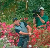  ?? — AFP ?? Rory McIlroy of Northern Ireland hits a shot out of bushes behind the 13th green during the second round of the Masters Tournament at Augusta National Golf Club in Augusta, Georgia (USA), on Friday.