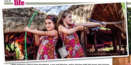  ??  ?? Little warriors: Saba’s twin daughters, Luna and Mayian, enjoy playing with the bows and arrows they got for their sixth birthday. At their Kenyan home, the family live among the Samburu tribe