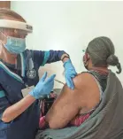  ?? DAMIAN DOVARGANES/AP ?? Los Angeles health workers administer COVID-19 vaccinatio­ns on Feb. 24.