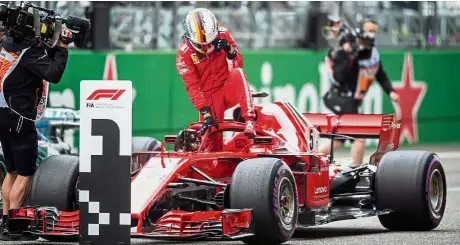  ??  ?? Well done: Ferrari’s Sebastian Vettel getting out of his car after taking the pole position for the Formula One Chinese Grand Prix in Shanghai yesterday. — AFP