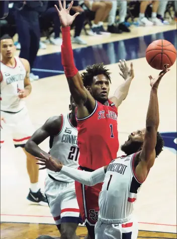  ?? David Butler II / Associated Press ?? UConn guard R.J. Cole shoots as St. John’s forward Josh Roberts (1) defends, in the first half on Sunday in Storrs.