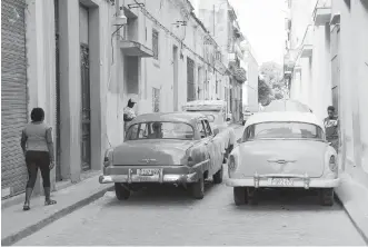  ?? DAVID SOVKA ?? American-made cars from the early 1950s block a narrow street in Havana.