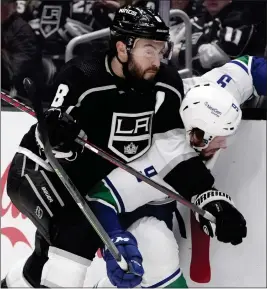  ?? PHOTOS BY MARCIO JOSE SANCHEZ — THE ASSOCIATED PRESS ?? Kings defenseman Drew Doughty (8) presses Canucks center J.T. Miller against the boards during the first period of Saturday night's game at Crypto.com Arena.