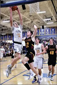  ?? Staff photo/Jason Alig ?? Tate Hess skies high for a shot while Nick Alig (12) launches to attempt to block the shot on Sunday night.