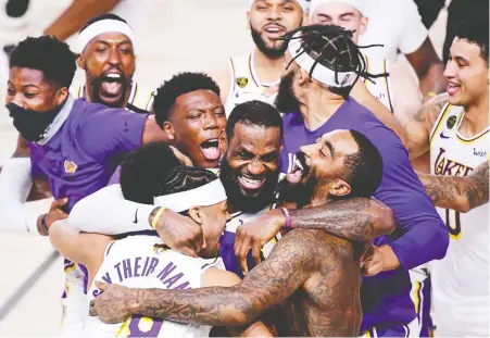  ?? DOUGLAS P. DEFELICE/ GETTY IMAGES ?? Lebron James is surrounded by his Los Angeles Lakers teammates as they celebrate winning the NBA championsh­ip last week in Lake Buena Vista, Fla. It was the fourth Larry O'brien Trophy for James, who was named playoff MVP following each of those title runs.