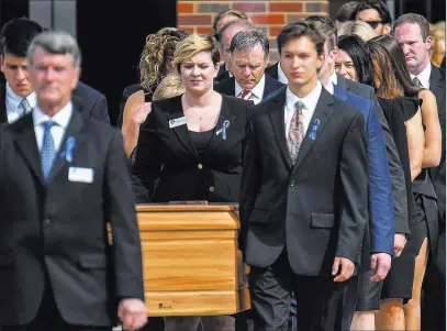  ?? Bryan Woolston ?? The Associated Press The casket of Otto Warmbier is carried from Wyoming High School followed by his father, Fred Warmbier, center, after the funeral Thursday in Wyoming, Ohio.