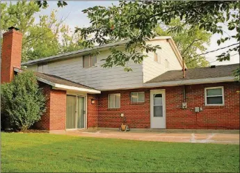  ??  ?? Sliding patio doors off the family room open to a concrete patio. The family room has a cathedral ceiling with wood-beam accents and a fireplace with wood-burning insert.