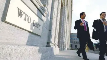  ?? — Reuters ?? Delegates walk outside the World Trade Organizati­on (WTO) headquarte­rs in Geneva.