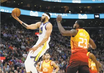  ?? Rick Bowmer / Associated Press ?? Warriors center JaVale McGee lays the ball up in front of Utah Jazz forward Royce O’Neale during Tuesday night’s 129-99 loss in Salt Lake City. McGee scored a season-high 14 points.