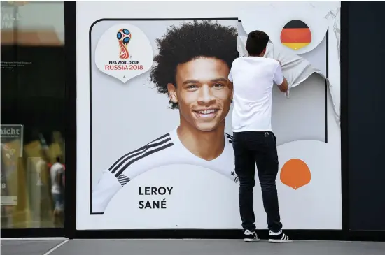  ?? AP ?? A poster of Leroy Sane is taken off the wall of the German soccer museum in Dortmund after he was left out of their World Cup squad