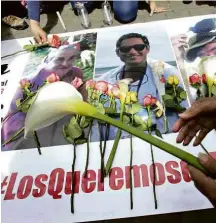  ?? Dolores Ochoa/Associated Press ?? Mulher põe flores em cartaz com fotos dos sequestrad­os