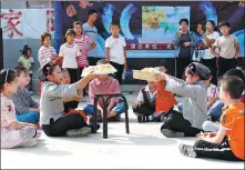  ??  ?? Students from Zhuojing School in Weifang perform the drama Nianyue, created in combinatio­n with the local Mid-Autumn Festival custom.