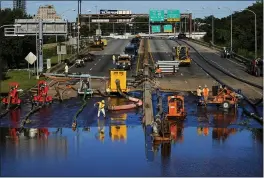  ?? MATT ROURKE — THE ASSOCIATED PRESS ?? Workers pump water from a flooded section of Interstate 676in Philadelph­ia on Friday.