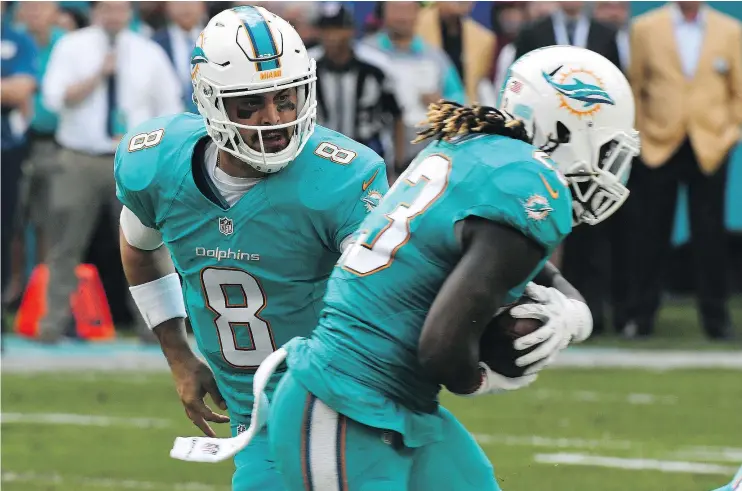  ?? — GETTY IMAGES FILES ?? The Miami Dolphins’ Matt Moore, shown handing off to Jay Ajayi on Sunday, has been forced to try to fill the shoes of injured QB Ryan Tannehill.