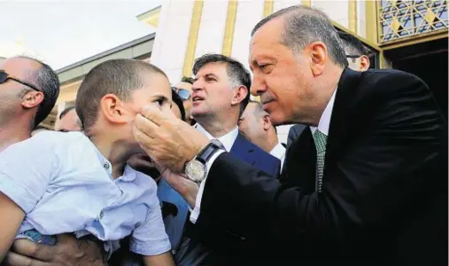  ??  ?? PRESSING THE FLESH: Turkish President Recep Tayyip Erdogan talks to a child before prayers at a mosque in Ankara yesterday