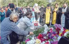  ?? — AFP ?? People lay flowers for the victims during a church service in Kerch, Crimea, on Thursday, after a student opened fire at a technical college in the Russian-annexed Crimea city of Kerch.