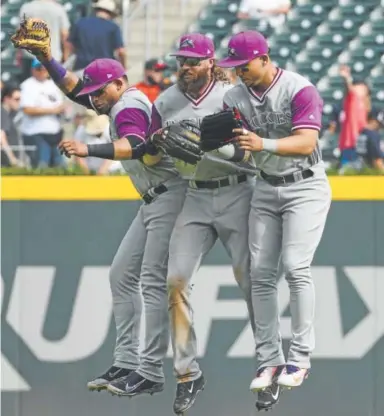  ?? John Amis, The Associated Press ?? From left, outfielder­s Gerardo Parra, Charlie Blackmon and Carlos Gonzalez celebrate Sunday after the Rockies wrapped up their road trip with a 3-0 victory over the Braves in Atlanta.
