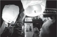  ?? CARLO ALLEGRI / REUTERS ?? People release paper lanterns outside Madiba, a restaurant named in honor of Nelson Mandela, on Thursday, in New York.