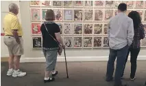  ?? PHOTOS: BETH J. HARPAZ/THE ASSOCIATED PRESS ?? Visitors at the Norman Rockwell Museum in Stockbridg­e, Mass., check out a display of the artist’s magazine covers for the Saturday Evening Post.