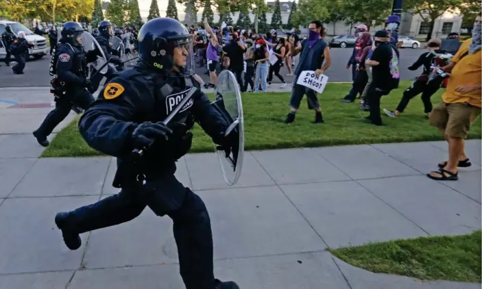  ?? Photograph: Rick Bowmer/AP ?? A Salt Lake City police officer at a protest earlier in July. Police foundation­s – which provide funds to local police department­s – in cities such as Salt Lake are partially funded by corporate names.