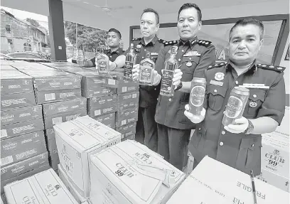  ?? — Gambar Bernama ?? DIRAMPAS: ACP Shamsul (dua kanan) bersama pegawai menunjukka­n pelbagai jenis arak kepada pemberita pada sidang media mengenai rampasan arak tanpa cukai di Ibu Pejabat Polis Daerah Klang Selantan, Klang semalam.