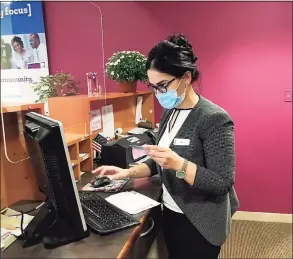  ?? Luther Turmelle / Hearst Connecticu­t Media ?? Mina Ghazi, a branch operations supervisor, looks up past transactio­n for a customer at the College Street Liberty Bank location in New Haven.