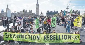  ?? STEFAN ROUSSEAU
THE ASSOCIATED PRESS ?? Demonstrat­ors take part in an Extinction Rebellion protest on Westminste­r Bridge in London on Friday.