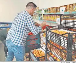  ?? BELÉN DELGADO / EFE ?? Un voluntario coloca fruta en un economato de Madrid.