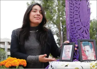  ?? Nikolas Samuels/The Signal ?? Yadira Gutierrez of the Global Citizens Associatio­n club shows the different pieces of an altar set up in honor of Dia de los Muertos on Wednesday at College of the Canyons.