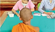  ??  ?? A young monk gets his health checked