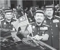  ?? — Gambar Bernama ?? BULAN MERDEKA: Mustafar melekatkan Jalur Gemilang pada kenderaan rasmi jabatan bersempena Bulan Kemerdekaa­n pada majlis Perhimpuna­n Bulanan Jabatan Imigresen di Putrajaya, semalam.