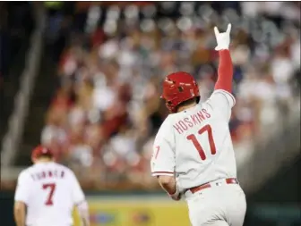  ?? NICK WASS — THE ASSOCIATED PRESS ?? The Phillies’ Rhys Hoskins gestures as he rounds the base after his two-run home run during the third inning Sunday against the Washington Nationals. Also seen is Nationals shortstop Trea Turner (7). The game featured a lengthy rain delay and ended too late for this edition.