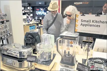  ?? PHOTOS BY MARY ALTAFFER — THE ASSOCIATED PRESS ?? Shoppers browse items on display at the Amazon 4-star store that recently opened in the Soho neighborho­od of New York.