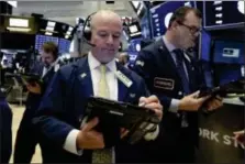  ?? RICHARD DREW — THE ASSOCIATED PRESS ?? Trader Patrick Casey, center, works on the floor of the New York Stock Exchange, Wednesday.