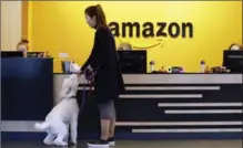  ?? ELAINE THOMPSON, THE ASSOCIATED PRESS ?? An Amazon employee gives her dog a biscuit as the pair head into a company building, where dogs are welcome, in Seattle.