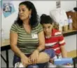  ?? JOHN RAOUX — THE ASSOCIATED PRESS ?? In this Tuesday photo, recent transplant from Puerto Rico, Arieliss Valencia sits next to her son Anthony, right, a fifth grader at Riverdale Elementary School after school supplies were handed out to the students in Orlando, Fla.